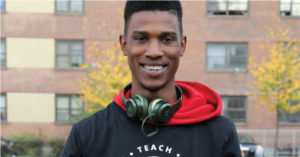 Male with medium-dark skin tone smiling.