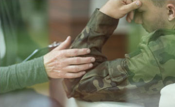 Health care provider holding the arm of a veteran.