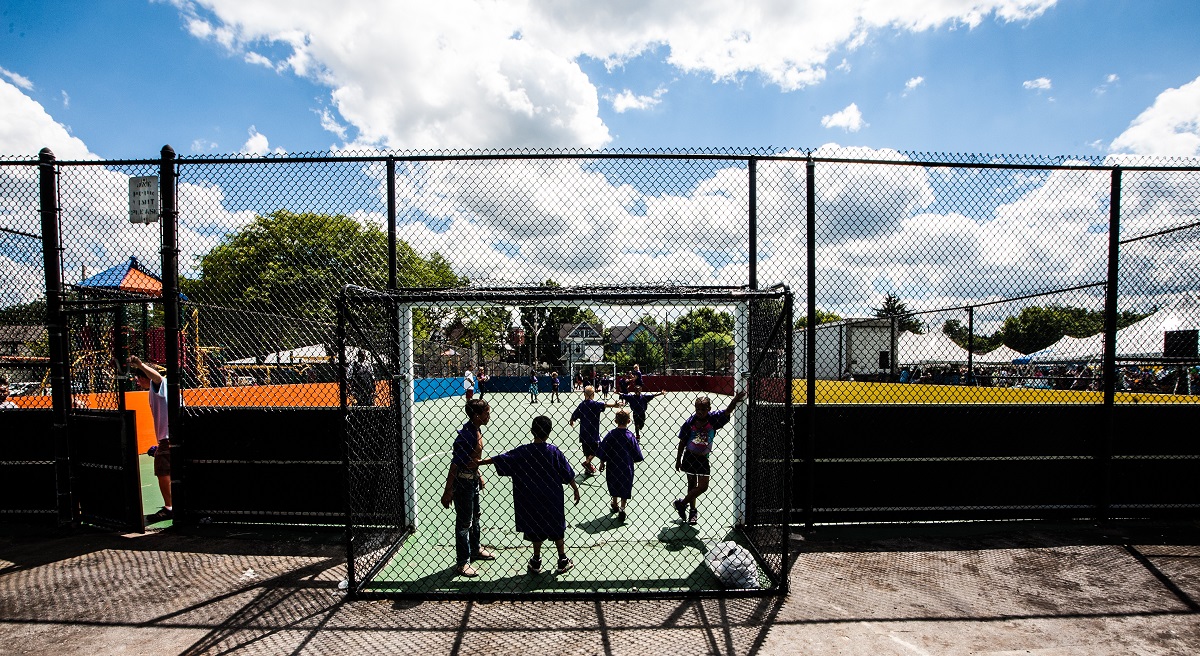 A fenced in soccer court showing young children playing sports in Near Westside, Syracuse.