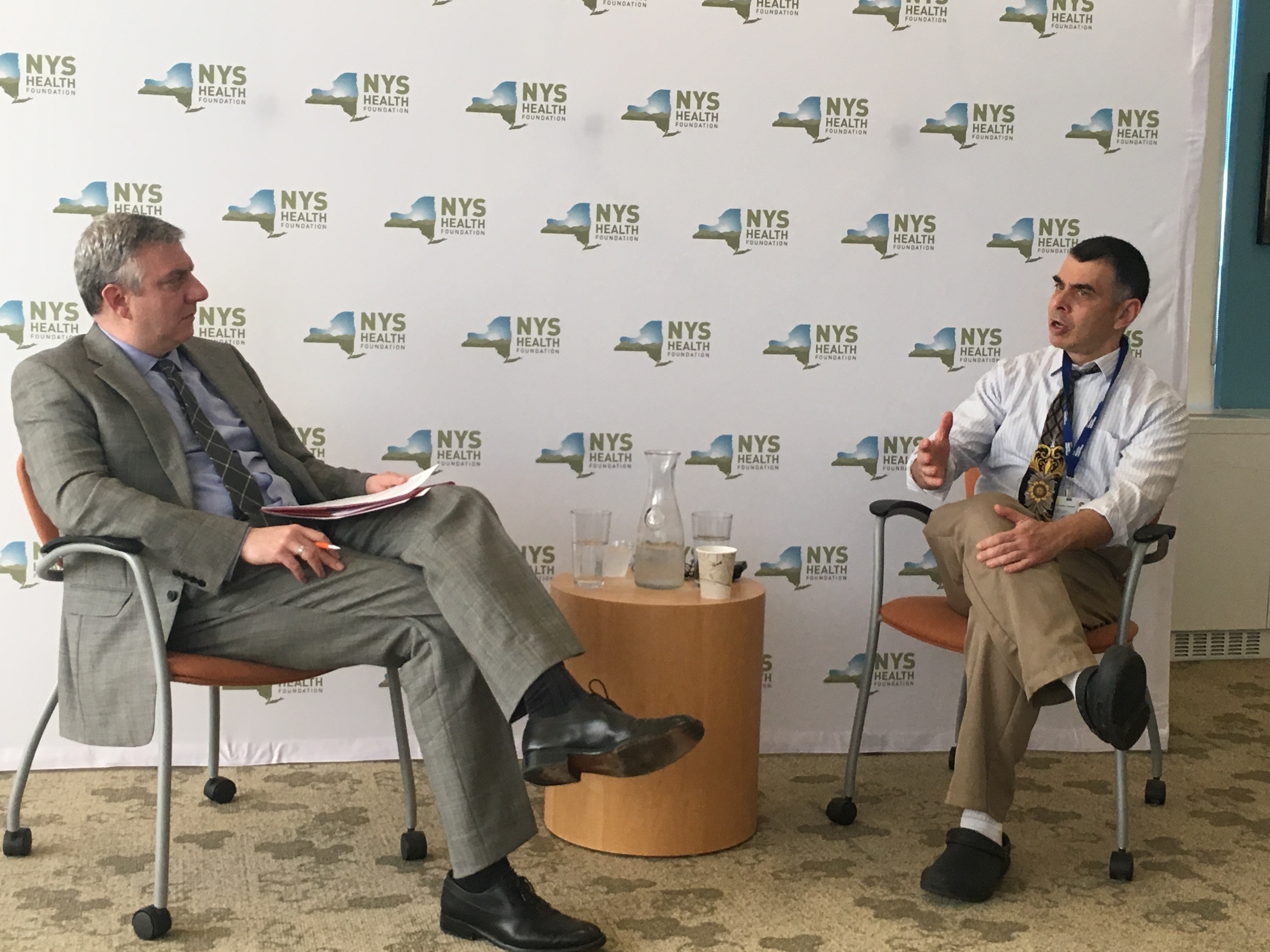 NYHealth President and CEO David Sandman talks with NYC Health + Hospitals CEO Mitchell Katz at the front of a conference room.