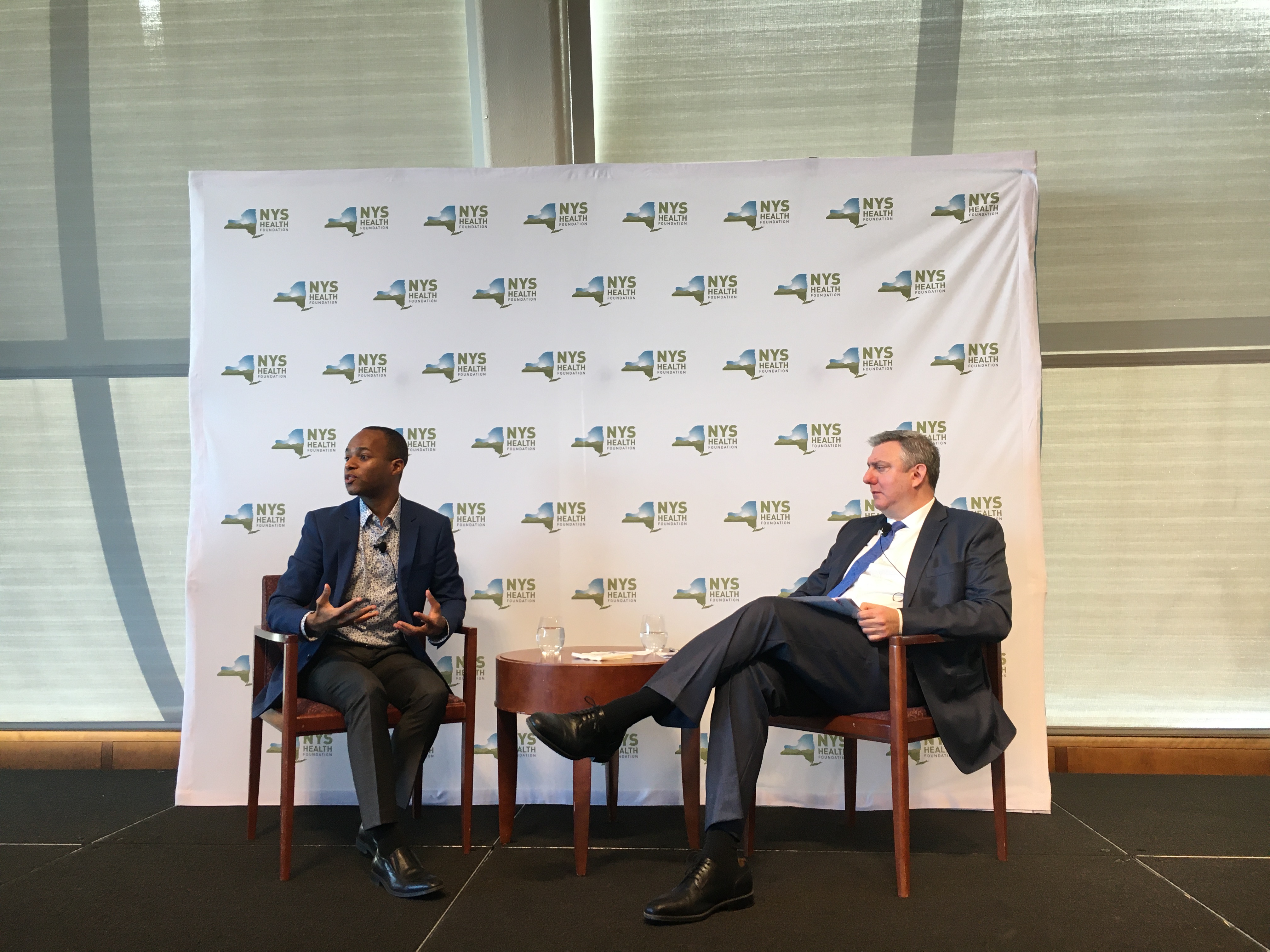 David Sandman, President and CEO of NYHealth, sits on stage with keynote Justin Garrett Moore at an NYHealth conference.