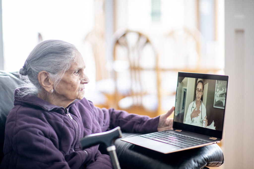 Elderly woman engages in virtual appointment with her health care provider. 